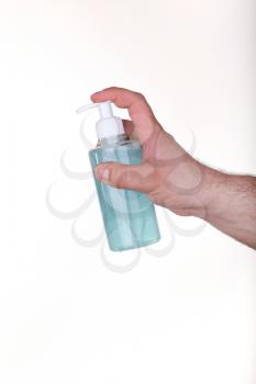male hand holding a bottle with blue sanitizer isolated in white background. concept of Prevention of diseases. Covid-19.