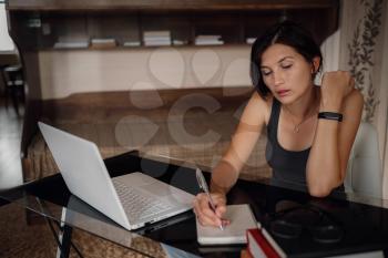 Young asian female student using laptop, communicates on internet. Cozy office workplace, remote work, E learning concept.