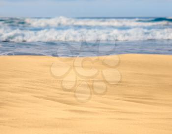 Smooth and sandy beach leading into the distance with waves
