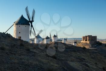 Preserved historic windmills with castle on hilltop above Consuegra in Castilla-La Mancha, Spain