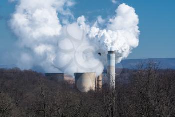 Smoke and steam billowing from chimneys and cooling towers of coal powered power station in West Virginia
