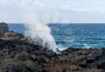 Famous Nakalele blowhole on north coast of Maui erupts as strong waves crash against the lava shoreline in Hawaii