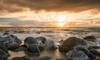 Sun setting over the Pacific ocean and worn rocks from Ke'e Beach on north of Kauai, Hawaii