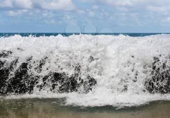 Strong surf and waves break over the rocks at Lumahai beach frozen to look like milk