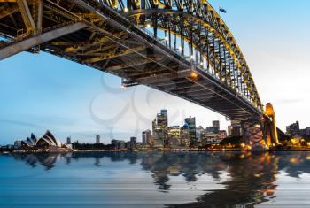 Dramatic widescreen panoramic image of the city of Sydney at sunset with water replaced by digital reflection.