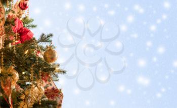 Ornately decorated christmas tree with snowing blue background for copy space for holiday message
