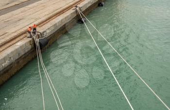 Men removing ropes holding cruise ship in harbour of Cadiz in Spain
