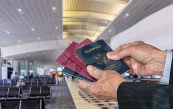 Senior caucasian businessman arm choosing to show US or EU or UK passport at immigration