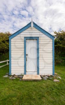 Colorful painted beach hut on its own plot of land along the coast of Devon in Southern England
