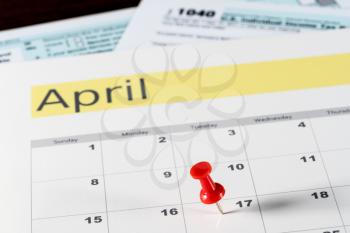 Calendar on top of form 1040 income tax form for 2017 showing tax day for filing is April 17 2018