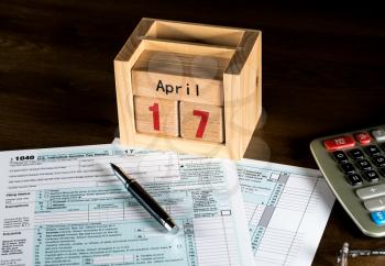 Calendar on top of form 1040 income tax form for 2017 showing tax day for filing is April 17 2018