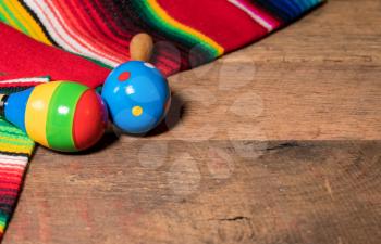 Cinco de Mayo background image on with maracas and serape on wooden rustic boards