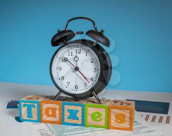 Alarm clock approaching midnight on tax day and taxation forms not completed