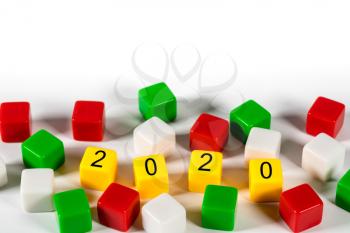 2020 spelled in blocks among other colorful dice on white background for New Years concept
