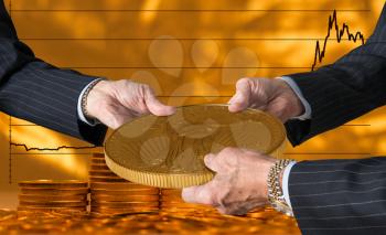 Hands of three financial traders gripping gold eagle coin against a background of rising prices for the currency