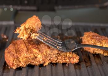 Close shot of the meat like plant-based patties for vegetarian beef burgers being grilled on hot griddle