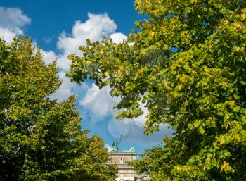 Unusual view of the Brandenburg gate in Berlin, Germany, through the autumn trees
