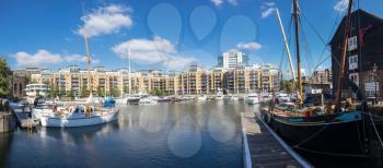 LONDON, UK - OCTOBER 1, 2015: Broad panoramic view of the boats and barges in St Katherines Dock in London, England