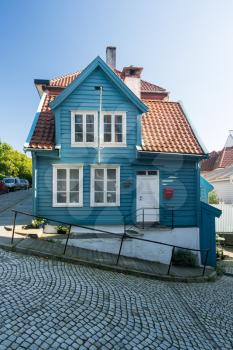 Colorful blue painted home on cobbestone street in the old town of Bergen in Norway