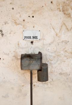 Poor box for donations to disadvantaged people on wall of old church