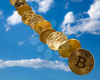 Bitcoin coins falling from the sky to illustrate the falling price of the cybercurrency