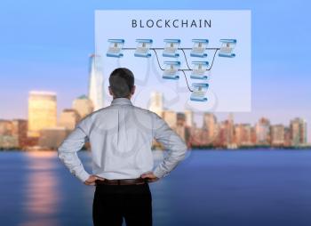 Blockchain schematic on glass panel with senior technology executive looking at the chart with New York city in background