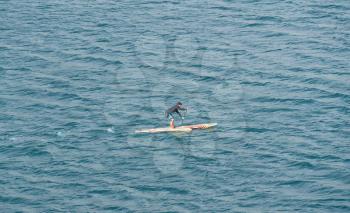 FUNCHAL, MADIERA - MARCH 12, 2018: : Man on paddle board crosses the harbor in Funchal on Madiera