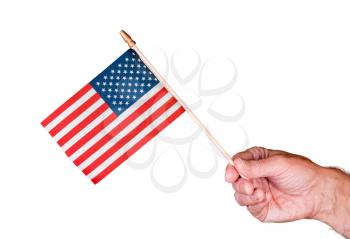 Senior mans hand holding a small toy USA flag and cutout against white background