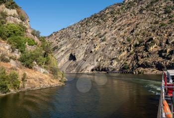 River boat cruising on Douro flowing through narrow rocky gorge in Portugal near Viseu