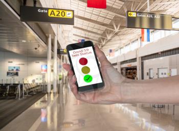 Mockup of airport terminal with hand holding smartphone app showing immunity to coronavirus