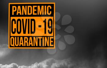 Pandemic sign warning of quarantine due to Covid-19 or corona virus in the USA using dark cloudy storm clouds in the background