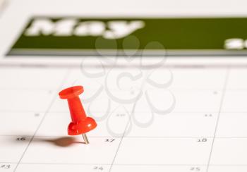 Calendar with pushpin inserted in the date for May 17 to illustrate the new tax return filing date of f17th May 2021.