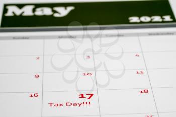 Calendar with Tax Day note inserted in the date for May 17 to illustrate the new tax return filing date of 17th May 2021.