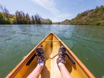 Caucasian man paddling in a pack canoe down the Monongahela river in Morgantown, West Virginia