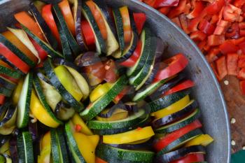 Ratatouille. Vegetable dish. Peasant food. Vegetables, cut into slices. Zucchini, pepper, tomato, eggplant. Kitchen. Recipes. Delicious. It is useful. Horizontal photo