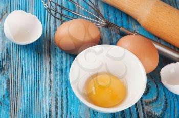 Eggs and egg yolk on a blue wooden background