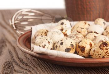 Quail eggs in a clay plate on a wooden table