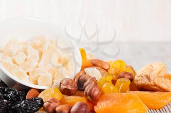 Dried fruits and nuts on a wooden background