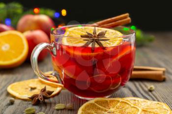 Mulled wine with spices and orange fruit on a black background. Traditional Christmas hot drink with red wine, oranges, anise and cinnamon