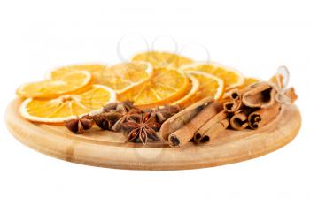Dried orange slices, cinnamon and star anise on a wooden board. Spices for mulled wine isolated on a white background.