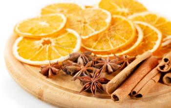 Dried orange slices, cinnamon and star anise on a wooden board. Spices for mulled wine on a white background.
