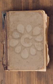 old shabby book with a blank cover lying on a rough board