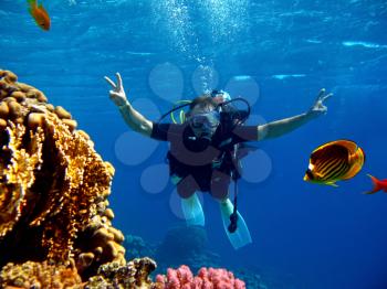 Male diver in scuba for the first time immersed with an instructor in the red sea near the coral reef