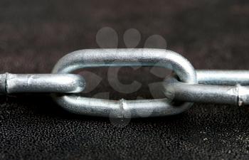 close up shot of a shiny metal chain on a dark background