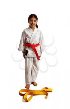 girl karateka successfully passed the certification and moves to a new level having received a belt of a different color