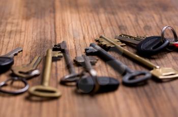 several keys of different years and shapes on an old wooden background