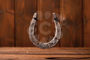 old classic horseshoe symbol of good luck over dark wooden background