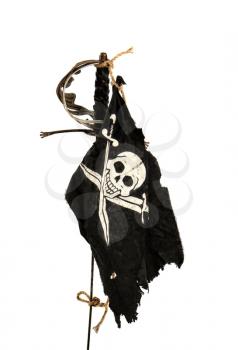 Black pirate flag winding up in the wind tied with a rope to an old sword