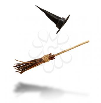 classic pointed witch hat and flying broom flying on a white background