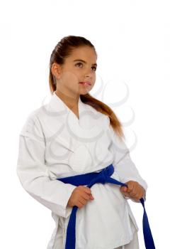 little karate girl in a white kimono ties a new blue belt